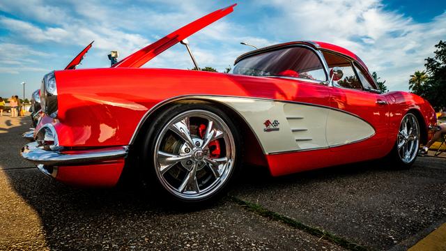Red and white C1 Corvette side profile at a car show