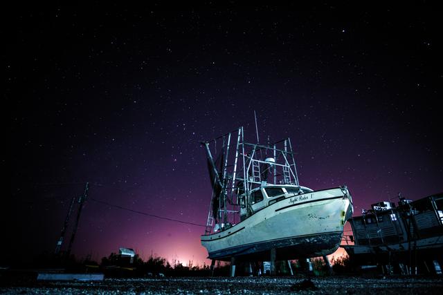Shrimp boat on dry dock beneath a starry night sky in coastal Louisiana